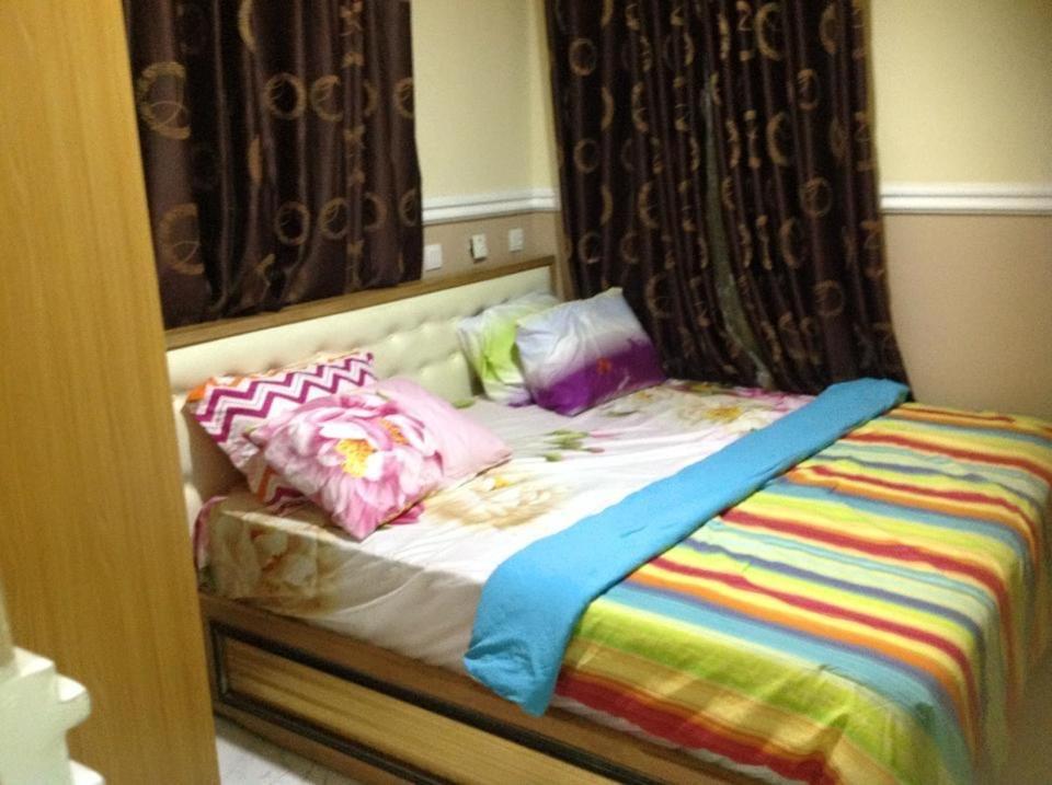 łóżko z kolorową pościelą i poduszkami w obiekcie Blue-View Suites & Apartments w mieście Abudża