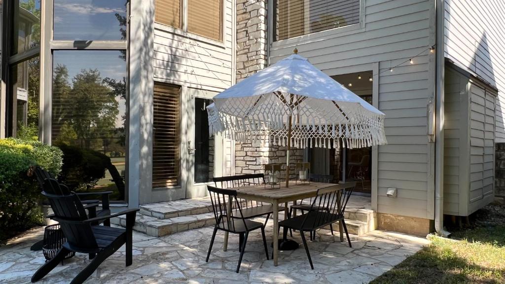 a patio with a table with chairs and an umbrella at Cozy tennis house in Lakeway