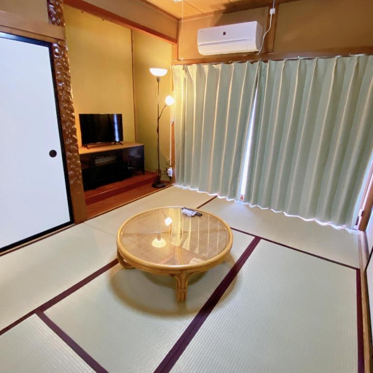 a living room with a table in the middle of a room at mooi 宮町 in Aizuwakamatsu