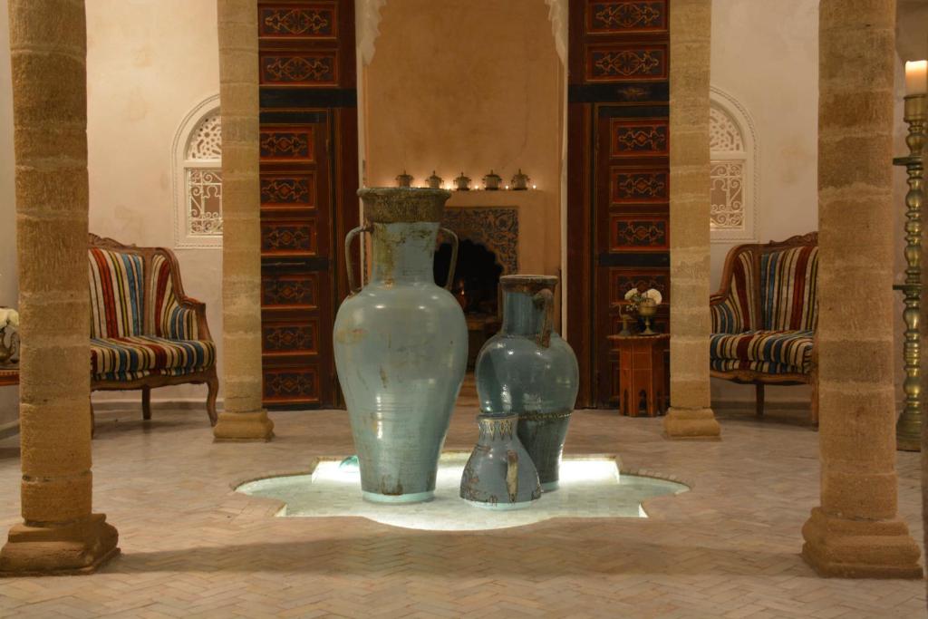 dos jarrones sentados en pantalla en una habitación en Riad MALAÏKA en Essaouira