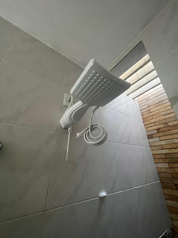a shower head on a wall in a bathroom at Ap próximo ao Arco com garagem in Sobral