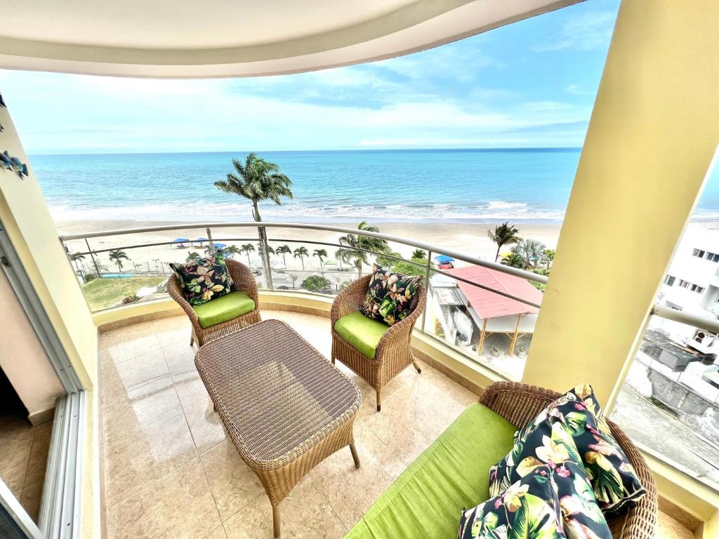 a balcony with chairs and a view of the beach at Encantador departamento frente al mar con WIFI in Tonsupa