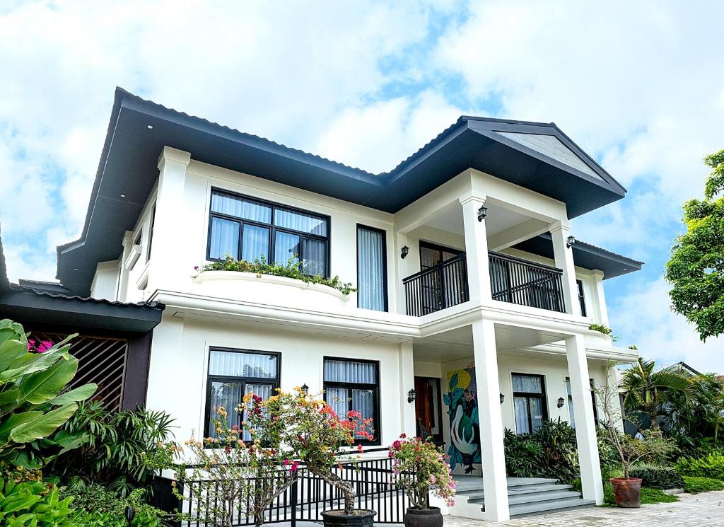 a white house with a black roof at UNWND Boutique Hotel Dumaguete in Dumaguete