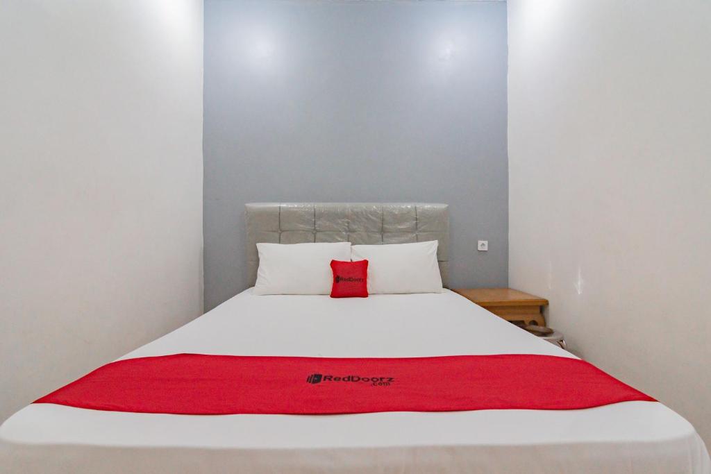 RedDoorz near Prujakan Station Cirebon tesisinde bir odada yatak veya yataklar