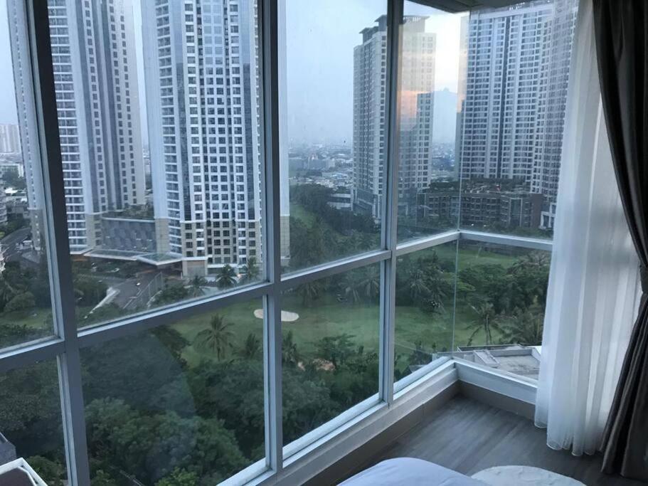 a bedroom with large windows with a view of a city at Not Ready, please do not make any reservation in Jakarta