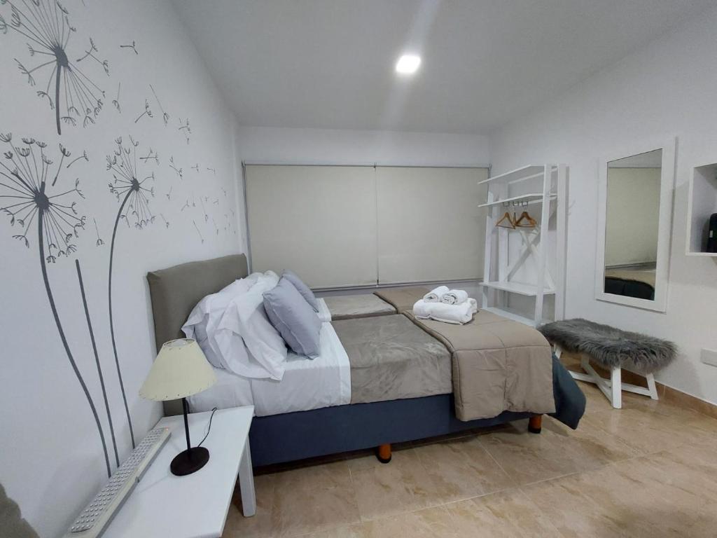 1 dormitorio con 1 cama con pared de diente de león en Calle 10 - Monoambiente, en La Plata