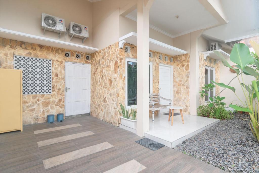 a room with a stone wall with a door and a table at D'Minggiran by Plesirhatiyogya in Timuran