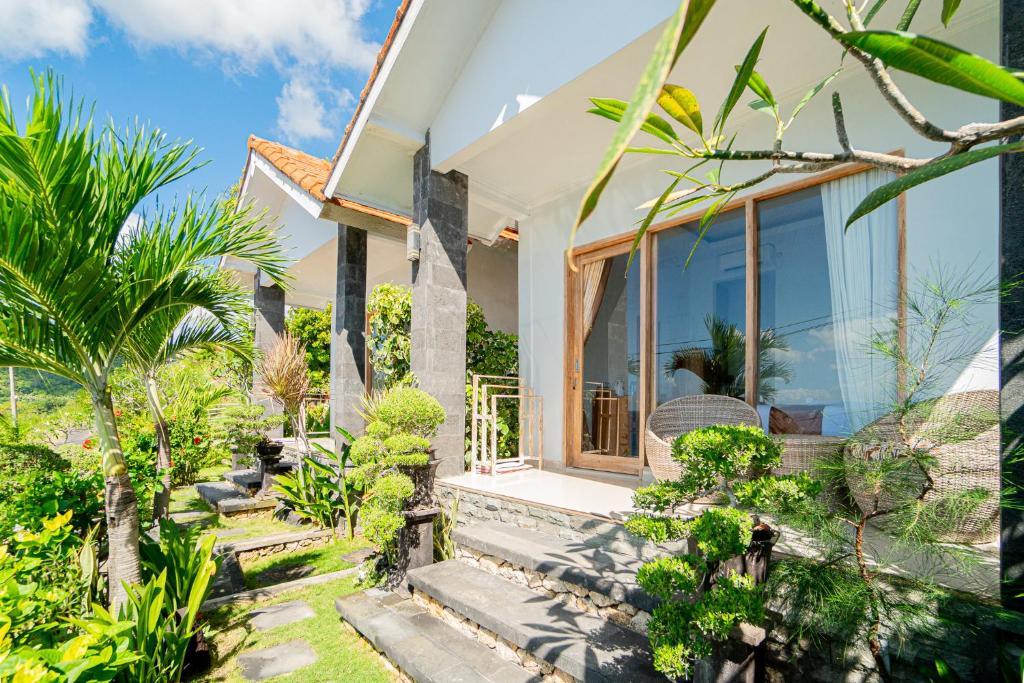 een huis met grote glazen deuren en planten bij Sekar Penida Cottages in Nusa Penida