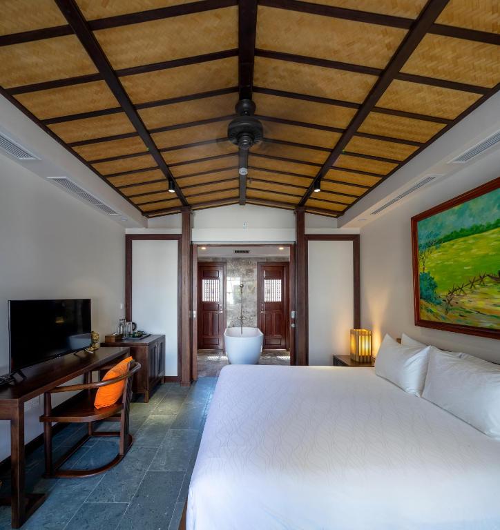 Postel nebo postele na pokoji v ubytování Nghê Prana Hotel and Spa Hoi An