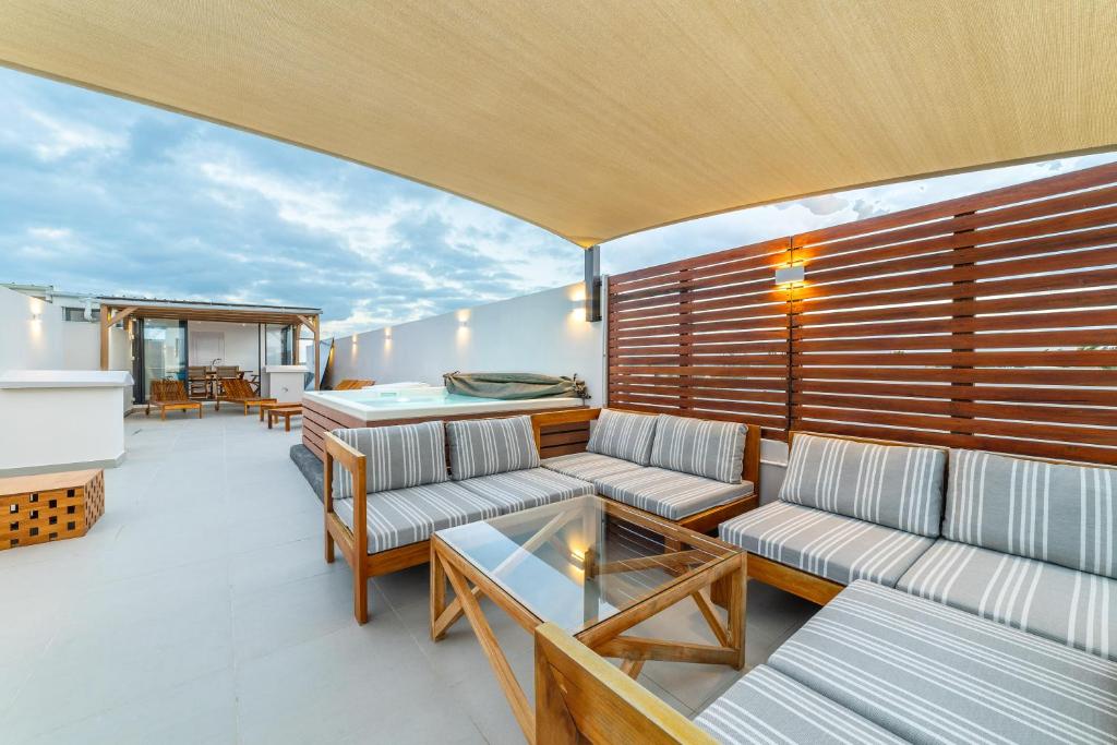 a balcony with couches and tables on a yacht at One Bay Residence Unit 15 - Penthouse with private roof top, jacuzzi and sea view in Grand Baie