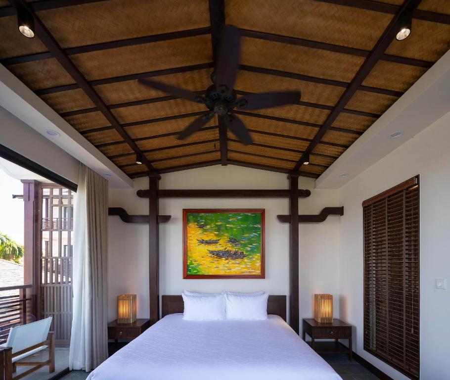 Postel nebo postele na pokoji v ubytování Nghê Prana Hotel and Spa Hoi An
