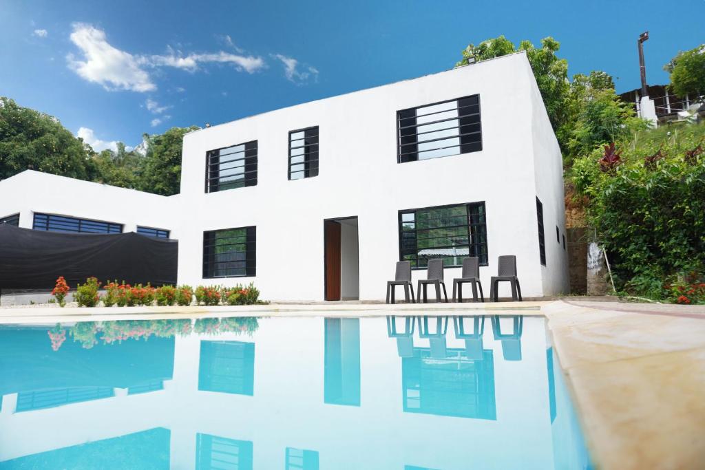 une maison blanche avec une piscine en face de celle-ci dans l'établissement VILLA MAJO, à Melgar