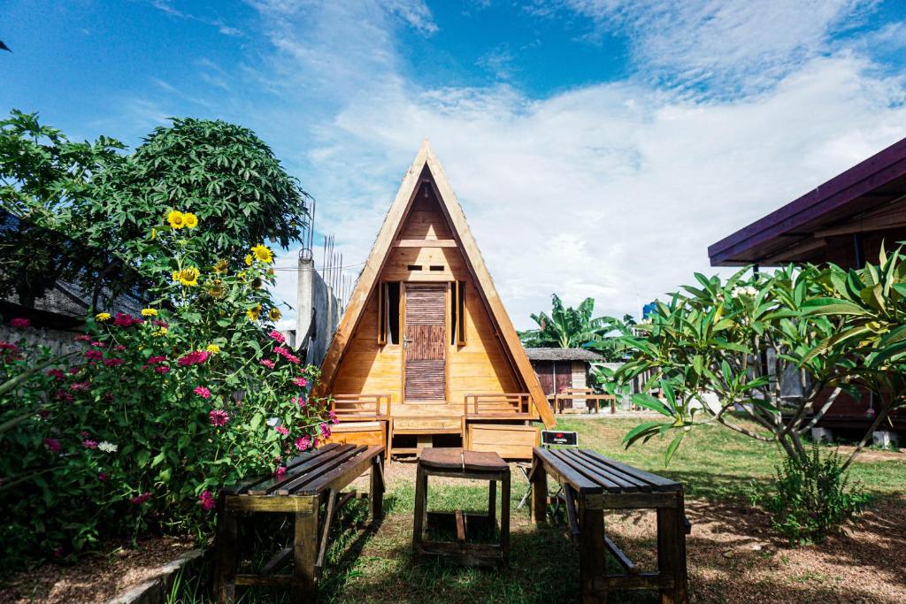 mały domek z dwoma ławkami na dziedzińcu w obiekcie Sinuan Homestay 