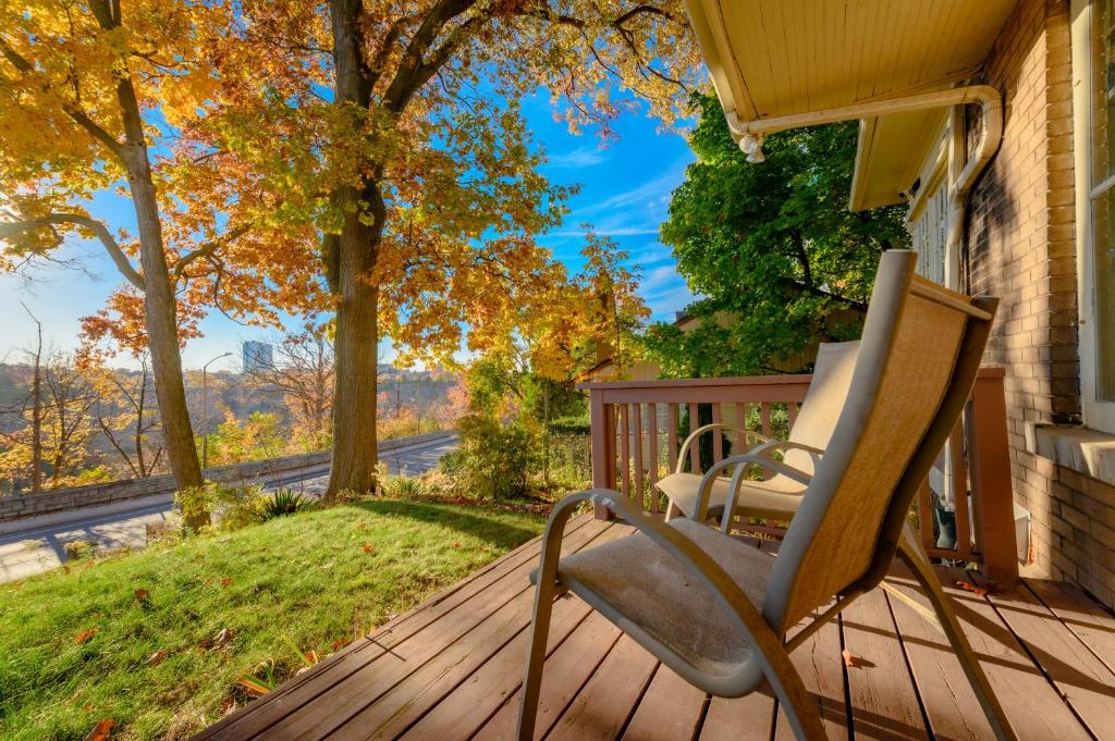 uma cadeira de balanço no alpendre de uma casa em Niagara River&Gorgeview Manor-10MinsWalkToFalls em Cataratas do Niágara