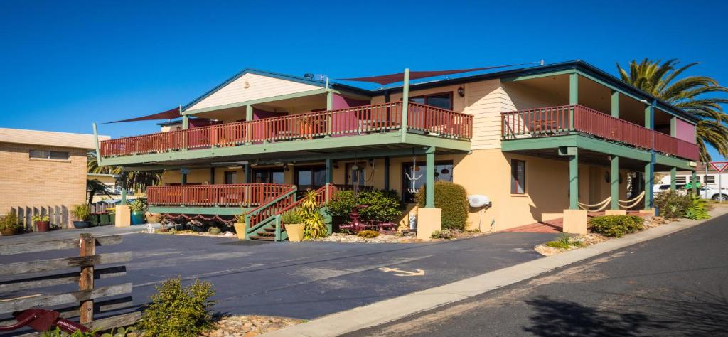 a large house with balconies on a street at Anchors Aweigh - Adult & Guests Only in Narooma