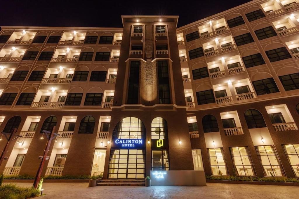 a building with a clock tower in front of it at Calinton Hotel in Udon Thani