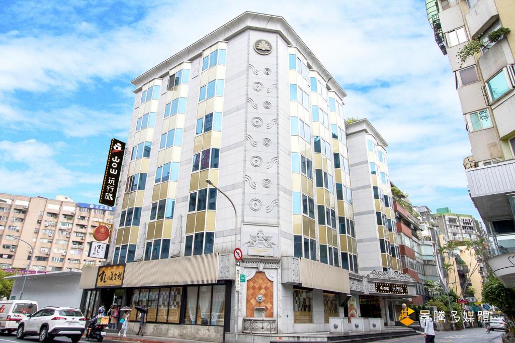 a tall white building with a clock on it at Wowhappy Daan in Taipei