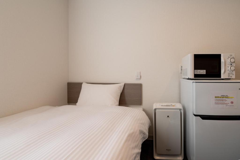 Postel nebo postele na pokoji v ubytování HOTEL R9 The Yard Shikokuchuo