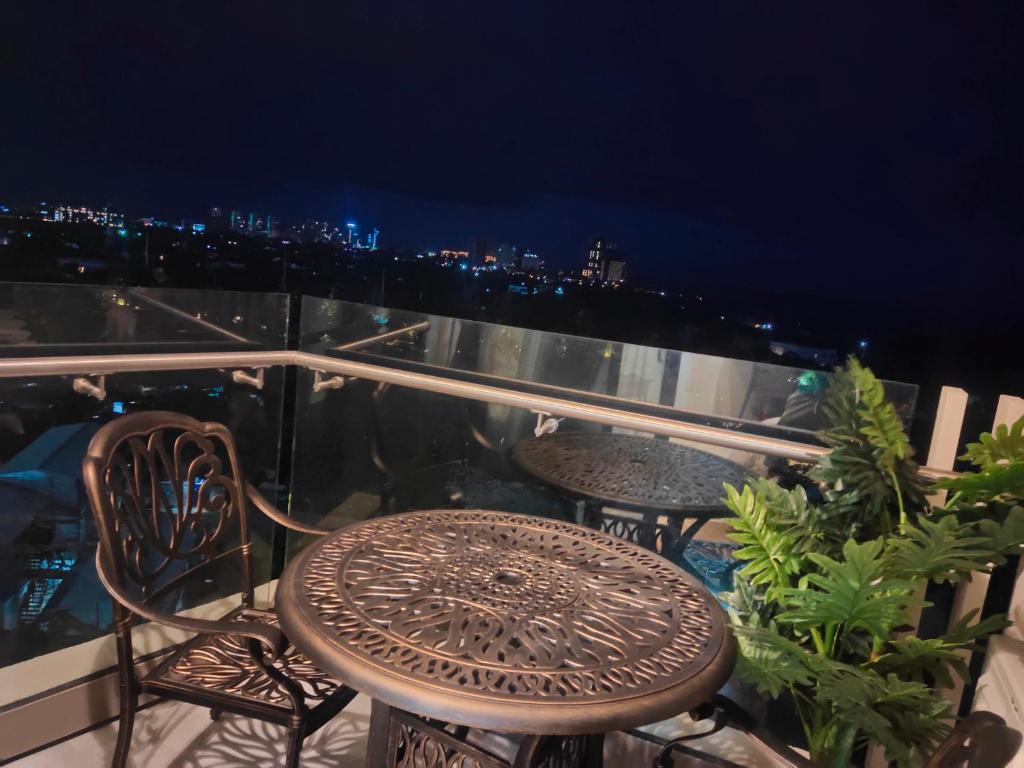 a table and chairs on a balcony at night at Tambuli Residence in Maribago