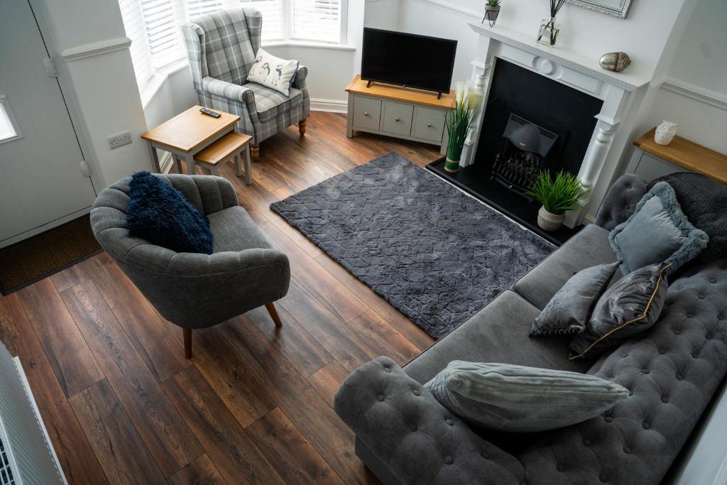 ein Wohnzimmer mit zwei Sofas und einem Kamin in der Unterkunft Wavecrest Retreat , Hot Tub & Garden, Sleeps 8 in Flamborough