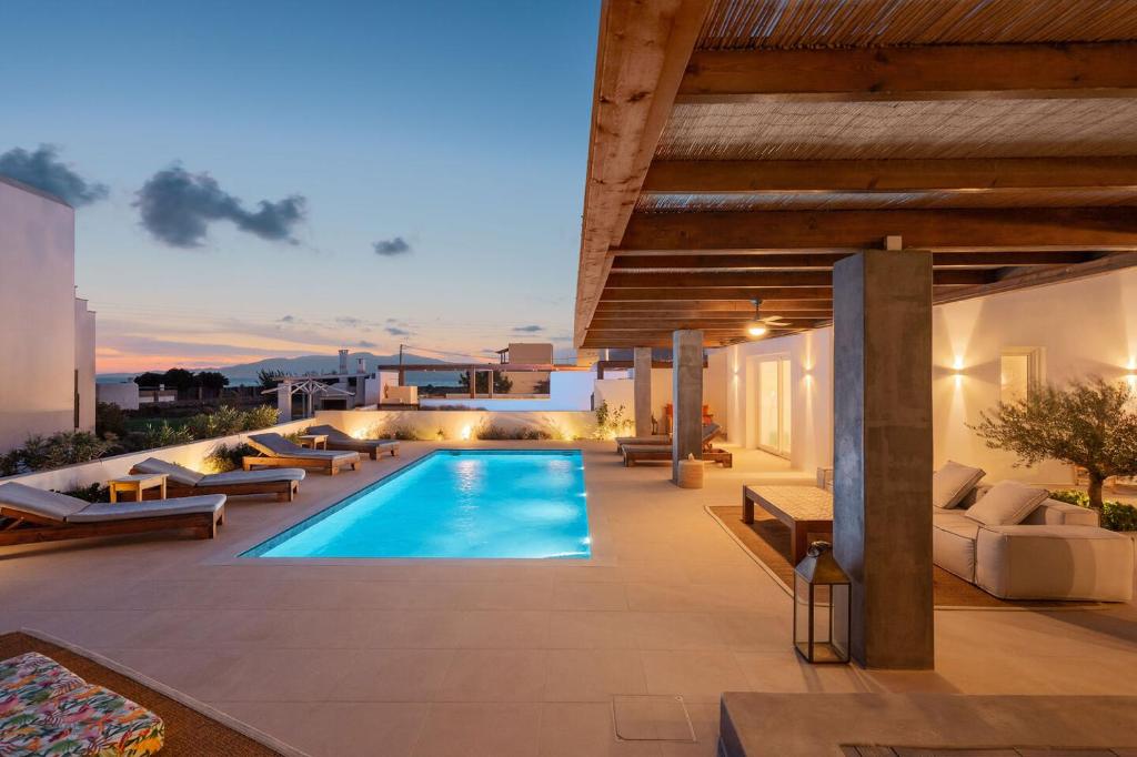 an outdoor patio with a swimming pool and furniture at Citrus Seaside Houses in Plaka