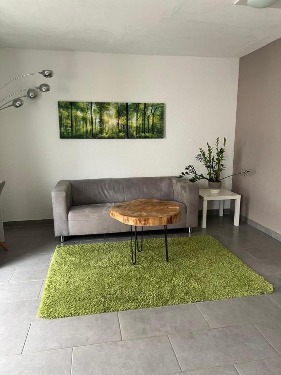 uma sala de estar com um sofá e uma mesa em Gemütliches Apartment nahe Porsche em Weissach