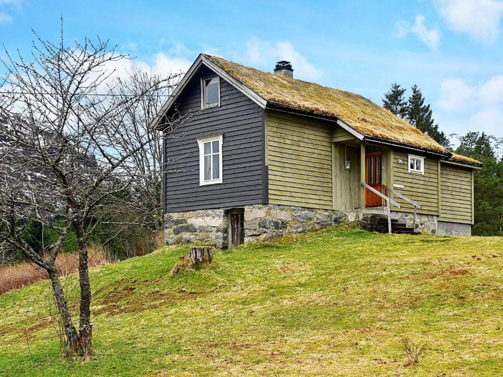 an old house on top of a grassy hill at Holiday home vassenden in Vassenden