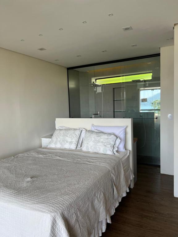 ウバトゥバにあるLoft maravilhoso, com vista sensacional do marの部屋にある大きな白いベッドのある寝室