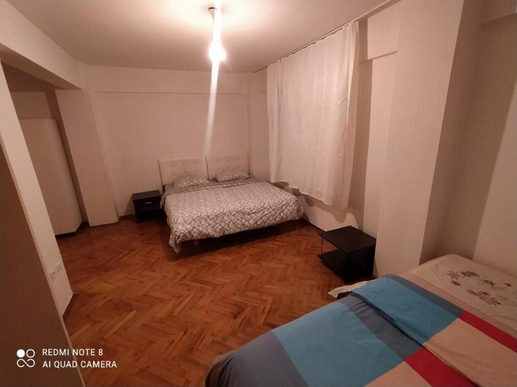 a small room with two beds and a wooden floor at Uncular Flat 3+1 in Istanbul