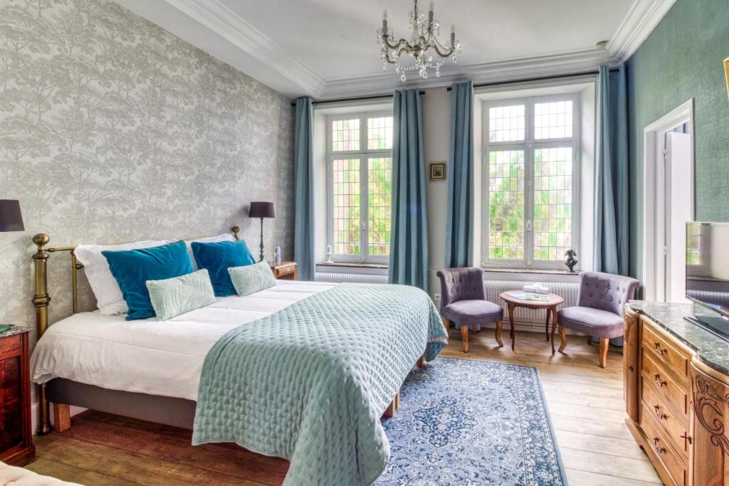 um quarto com uma cama, cadeiras e janelas em La Boulonnaise em Boulogne-sur-Mer