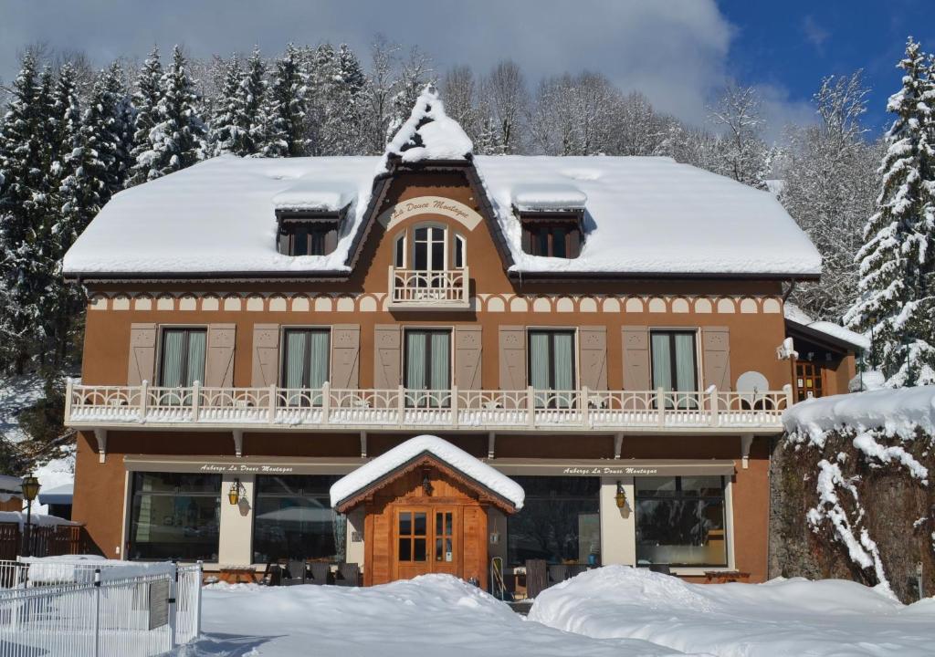 a large house with snow on the roof at Auberge La Douce Montagne in Allemont