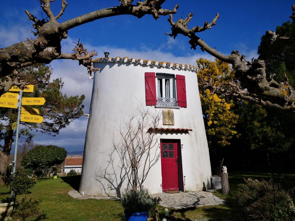 mały biały budynek z czerwonymi drzwiami i oknem w obiekcie Hotel Ô Fil de L'ô w mieście Marseillette