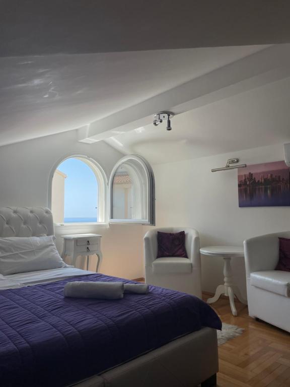 una camera con un letto e due sedie e un tavolo di Apartmani IVA Bečići a Bečići