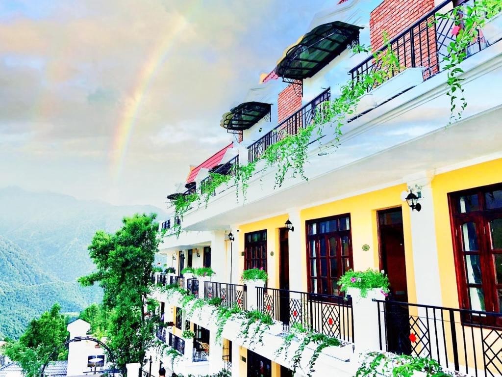 a rainbow over a building with a balcony at Cat Cat Galerie d’Art in Sapa