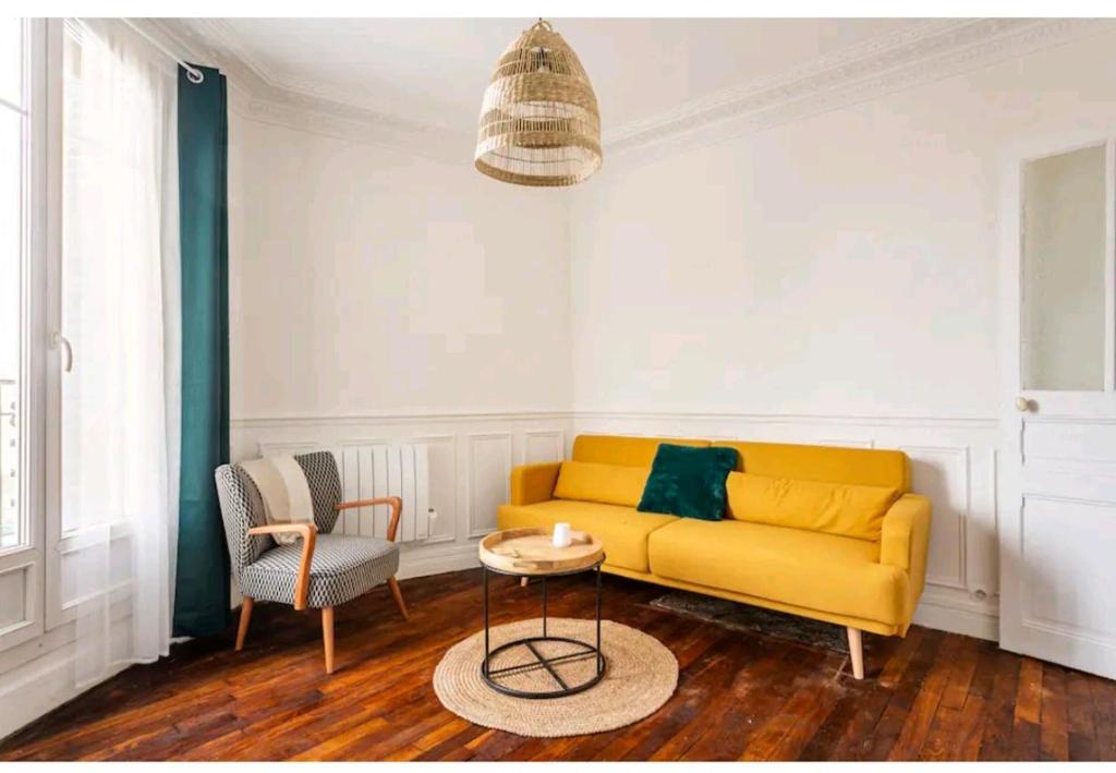 uma sala de estar com um sofá amarelo e uma mesa em Appartement au bord de seine em Épinay-sur-Seine