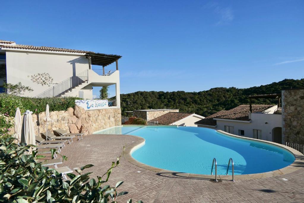 uma grande piscina em frente a uma casa em Residence con piscina a 4 km da Baja Sardinia em Cala Bitta