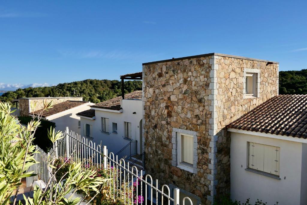 szereg domów z białym płotem w obiekcie Residence con piscina a 4 km da Baja Sardinia w mieście Cala Bitta