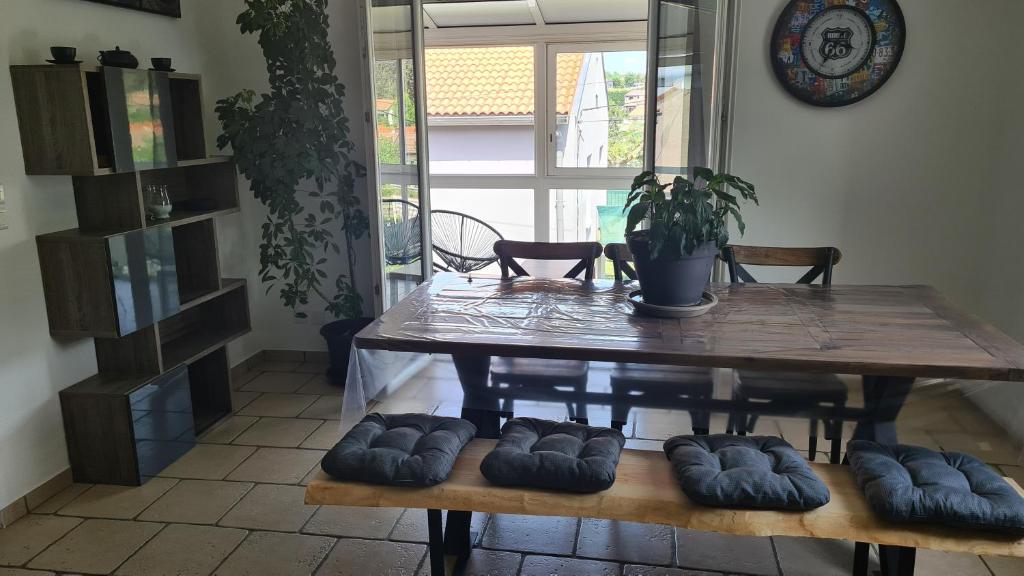 stół jadalny z 4 poduszkami wokół niego w obiekcie Maison familiale avec jardin clos et barbecue w mieście Le Puy-en-Velay