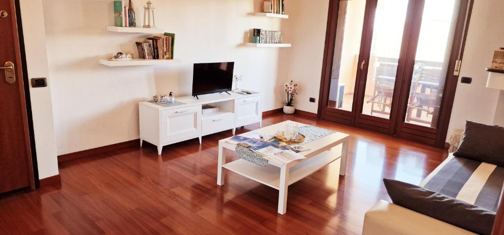 a living room with a table and a tv at Ancora Apartment in Quartu SantʼElena