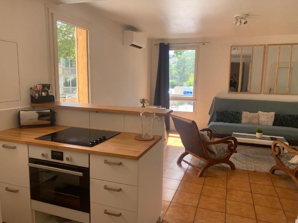 cocina y sala de estar con sofá en Beau T2 clim terrasse idéalement situé en Aix-en-Provence