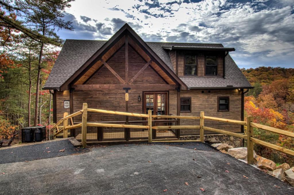 a log home with a wooden fence and a driveway at Honey Bear Hill #326 in Sevierville