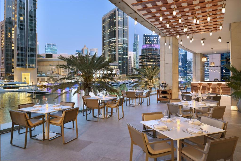 a restaurant with tables and chairs and a view of the city at InterContinental Dubai Marina by IHG in Dubai