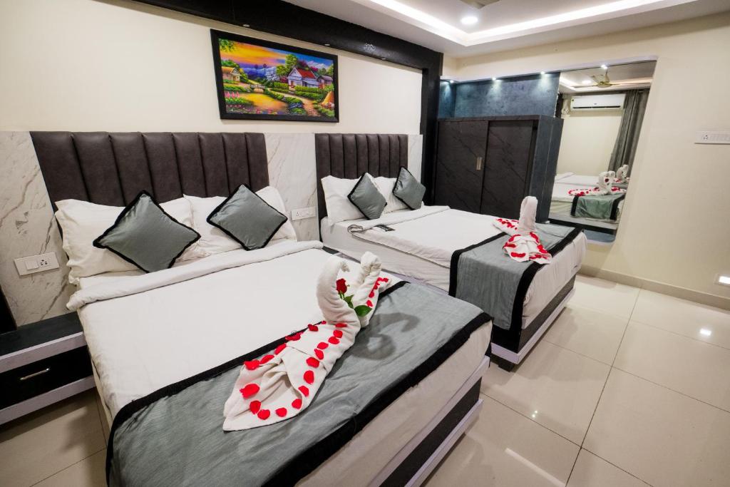a hotel room with two beds and a mirror at HOTEL PARAMESHWARA luxury awaits in Vijayawāda