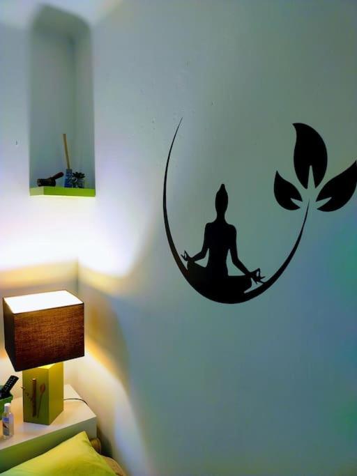 a room with a wall with a sticker of a woman sitting in meditation at Le Passe-Port pour Marseille in Marseille