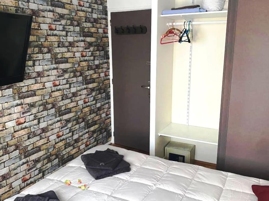 a bedroom with a brick wall and a bed at Le Passe-Port pour Marseille in Marseille