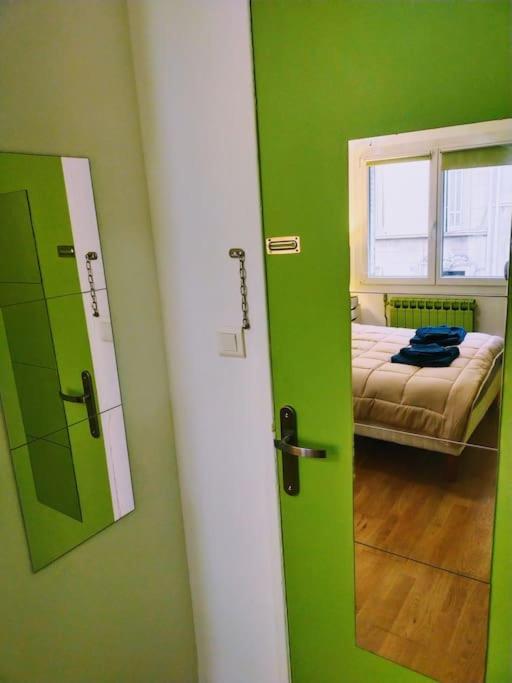 a green room with a bed and a mirror at Le Passe-Port pour Marseille in Marseille