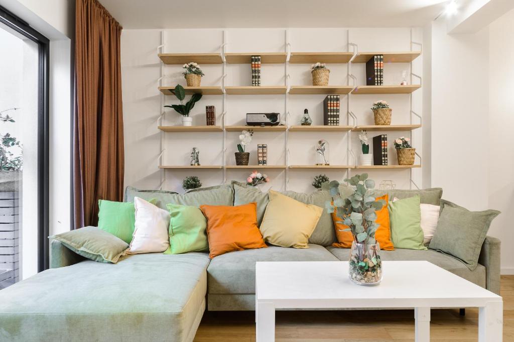 a living room with a couch with colorful pillows at Lumina I 2BR Apartment with Terrace I Parking I 100m2 I 2 Bathrooms in Łódź