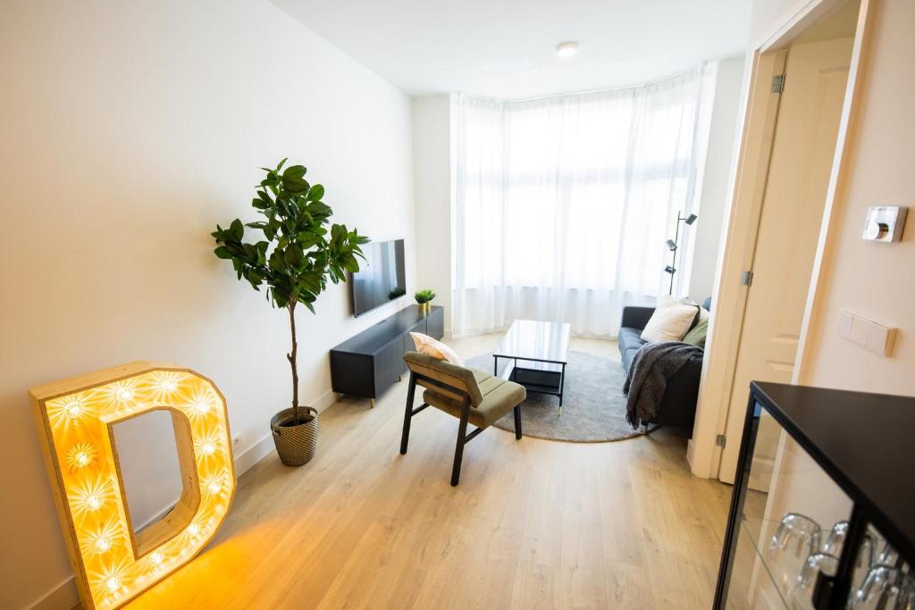een woonkamer met een spiegel en een bank bij Dearly 1 Bedroom Serviced Apartment 56m2 -NB306D- in Rotterdam