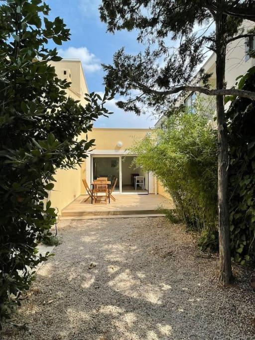 une maison avec une terrasse et une table sur une terrasse couverte dans l'établissement Grand studio neuf à Carry le Rouet, à Carry-le-Rouet