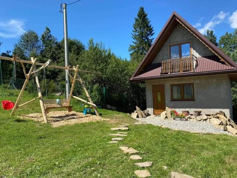 a small house with a yard with a yard at Domek na Górce in Zakopane